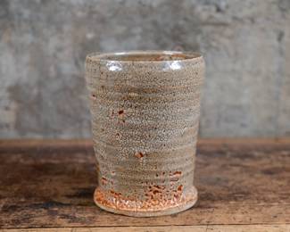 Mid-20th century ceramic vase with maker signature underneath. Features a textured, glazed finish in good overall condition.