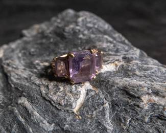 10K yellow gold ring with three purple colored stones. Approx. weight is 3.54 grams and is a size 5.5.