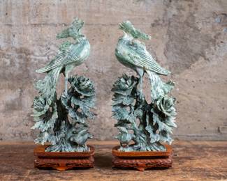 A pair of Dushan Nephrite Jade Phoenix sculptures. These sculptures feature birds perched amid foliage and are mounted on intricately carved wooden bases circa 20th century.