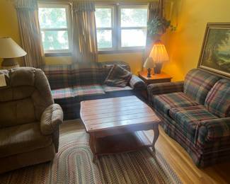 Rug couch, coffee table, lamps, side table, curtains, plant, macrame plant holder, chair