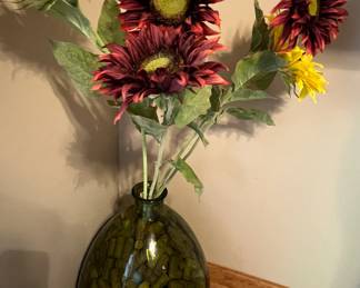 Large green glass vase filled with corks