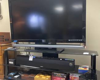 Samsung Soundbar and Subwoofer (Model Number PS-WX810), Oticon Hearing Aid TV Adapters, Various Board Games (such as Murder Mystery and Cribbage Set), Vizio 55 Inch TV (Model Number VF550XVT1A) 