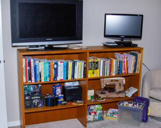 Samsung TVs, wooden shelf with various media 