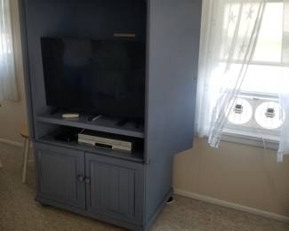 TV armoire; window fans; seashell and starfish curtains