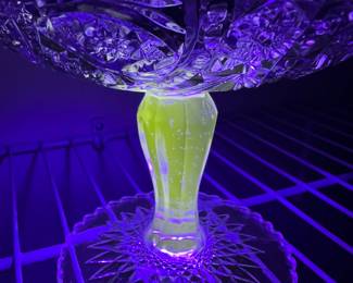 Uranium glass - there are 2 different amounts of uranium. The stem has a larger amount than the rest of the glass.