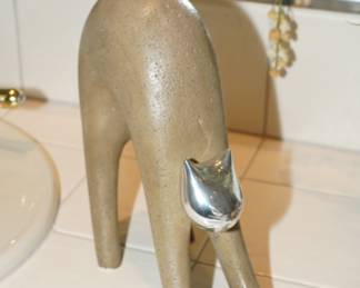 Stretching cat made of stone with silver head and tail