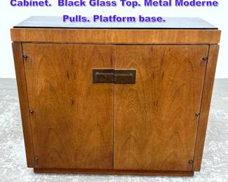 Lot 758 Narrow Two Door Modernist Storage Cabinet. Black Glass Top. Metal Moderne Pulls. Platform base. 