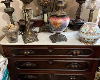 Various banquet lamps on Victorian chest