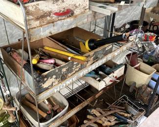 SO many old tools—hammers, saws, wrenches, and check out the metal shelf unit!