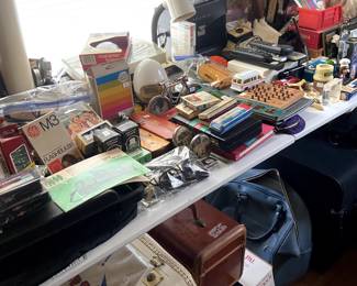 Lots of desk supplies, some old cameras and bulbs, suitcases, old radios, etc.