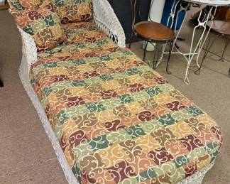Wicker chaise lounge with cushion and pillows