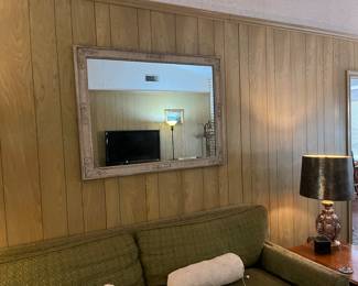 Large mirror and green down filled couch