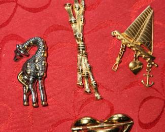 Giraffe is signed and is pin and a pendant. Sale boat is signed. 