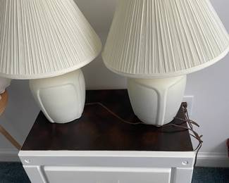 Small white cabinet and a pair of white lamps.