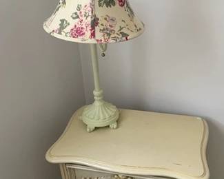 Small cabinet and cast iron lamp with floral shade.