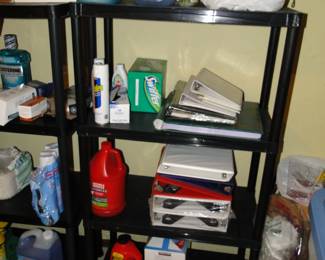 More metal shelving with notebooks, and cleaning supplies, and laundry supplies as well