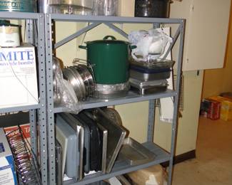 More metal shelving, with bakeware, cookware, baking sheets, bundt pans, and large and small canning pots, and 13 x 9 x 2 covered pans