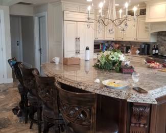 Kitchen features an island; upscale bar stools