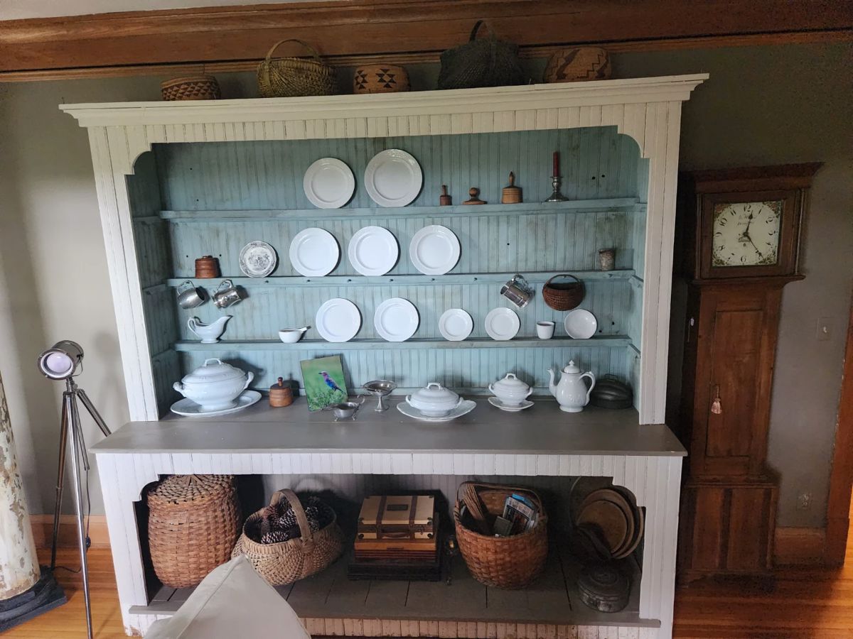 This large display cabinet is for sale. So are the ironstone, baskets, and clock