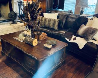 Coffee table, floral arrangement, cowhide rug, two matching recliners.