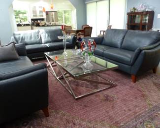 Natuzzi Editions "like new" pair of leather sofas and chaise, area rug, pair of chrome & glass coffee tables, bric-a-brac, area rug