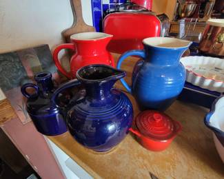 Two Le Creuset pitchers. Fiestaware water pitcher.