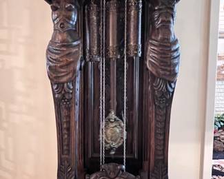 A Gazo Family ’The Californian’ 8ft tall ‘Open Well’ Case Clock Featuring Carved Oak Draped Figures with Etched Solid Brass Dial with Porcelain Numerals-(96”x27”x17”)..