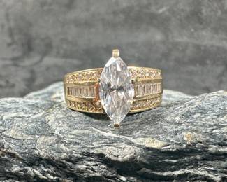 A 14K gold ring with clear stones (tested negative for Diamond). Gold professionally test positive for 14k with a total approx. weight of 6.47 grams. The ring is a size 10.