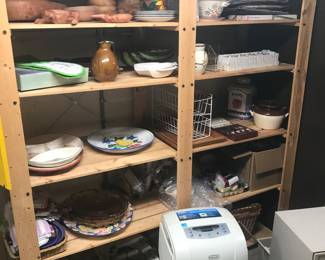 Lower level kitchen has shelving for sale stacked with serving platters and kitchenware!