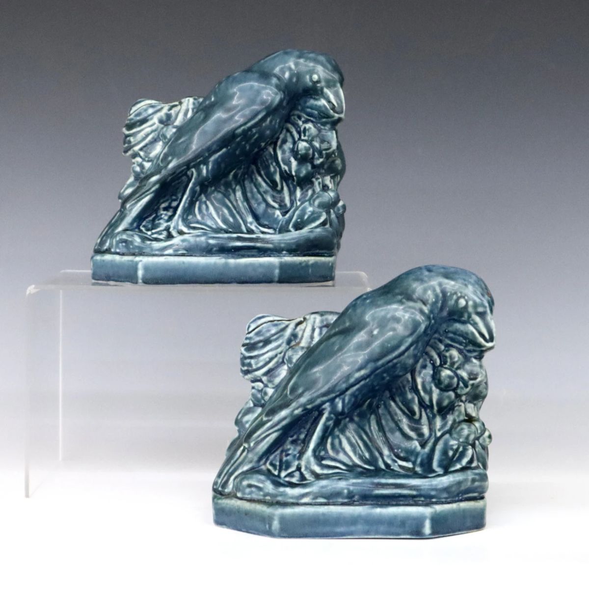 A pair of early 20th century Rookwood Art Pottery bookends designed by William Purcell McDonald (American, 1863-1931).  Molded forms depicting Rooks against a foliate background with Blue matte glaze.  Impressed Rookwood mark with "XXIV" (1924) date and "2275" model number.  Minor wear.  Both 5 1/2 x 5" high.  ESTIMATE $100-200