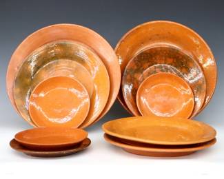 Ten 20th century Jugtown Pottery plates.  Circular forms with mottled Orange and Orange/Green Accidental glazes.  Includes two dinner plates, four salad plates, one desert plate and three saucers.  Surface wear, some crazing and flakes.  5 3/4" to 11" diameter.  ESTIMATE $50-75