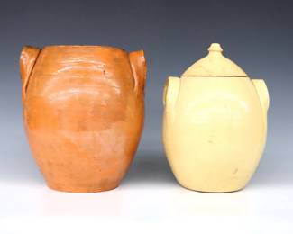 Two 20th century Jugtown Pottery cracker jars.  Ovoid forms with applied strap handles and mottled Orange/Green Accidental and Light Yellow Buff glazes.  Impressed "Jugtown Ware" marks.  Orange jar lacks lid, some crazing, flakes and small chips.  9 3/4" and 10 3/4" high.  ESTIMATE $50-100