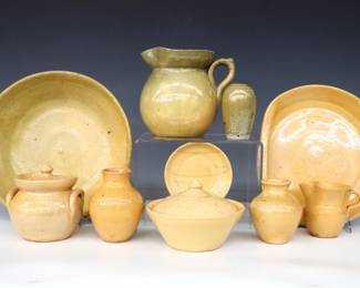 Ten pieces of 20th century Jugtown Pottery.  Various forms with mottled Light Yellow Buff and Yellow/Green glazes.  Includes a low bowl, serving dish with folded side handles, pitcher, covered pot, creamer and covered sugar, three small vases and a trinket dish.  Impressed "Jugtown Ware" marks.  Crazing, some with painted undersides and flakes.  Up to 10 1/4" diameter and 5 3/4" high.  ESTIMATE $50-100