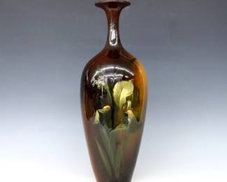 A turn of the century Weller Louwelsa Art Pottery vase.  Baluster form with slender neck, multi-color foliate decoration and Brown Standard glaze.  Impressed "Weller Louwelsa" mark with partial numerals.  Neck and shoulder with professional repair, some crazing and minor surface wear, small burst air bubble at body.  17 1/2" high.  ESTIMATE $50-75