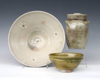 Three pieces of 20th century Jugtown Pottery.  Various forms, includes a footed bowl with Grey glaze and Dogwood floral decoration, a covered jar with mottled Grey/Brown salt glaze, and a small bowl with mottled Green Frogskin glaze.  Minor wear, bowl with production firing crack at foot.  Up to 9" diameter and 5 1/2" high.  ESTIMATE $50-100