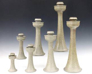 A set of seven late 20th century Vernon Owens for Jugtown Pottery candlesticks.  Flared forms with Stone Grey salt glaze.  Incised "Vernon Owens" signatures with "Jugtown Ware" marks and "1985" date.  Minor wear, lacks pair of smallest.  5" to 16" high.  ESTIMATE $200-300