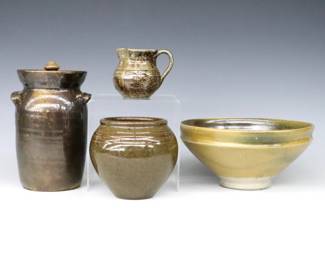 Four pieces of 20th century Jugtown Pottery.  Various forms with mottled Green Frogskin and Green/Brown salt glazes.  Includes a covered jar, footed bowl, round vase and creamer.  Impressed "Jugtown Ware" marks, vase dated "1982".  Minor wear, covered jar with hairline to rim.  Up to 7 3/4" diameter and 7 1/4" high.  ESTIMATE $50-100