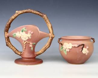 Two mid 20th century Roseville Art Pottery vases with multi-color Apple Blossom decoration and Pink matte glaze.  Includes a flared basket with scalloped rim and circular branch handle, and a rose bowl with two small branch handles.  Molded "Roseville / U.S.A" marks, larger with "969-8" and smaller with "964-6" model numbers.  Crazing and minor discoloration.  4 1/4" and 8 1/2" high.  ESTIMATE $50-100