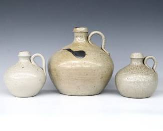 Three 20th century Jugtown Pottery jugs.  Bulbous forms with strap handles mottled Grey salt glaze, largest with burnished detail.  Impressed "Jugtown Ware" marks.  Minor wear, large jug with hairlines to underside that extend into body.  4 1/2" to 7" high.  ESTIMATE $50-75