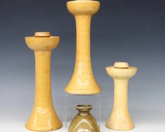 Four 20th century Jugtown Pottery candlesticks.  Includes a pair and single flared candlesticks with mottled Yellow Buff glaze, and a low candlestick with mottled Green Frogskin glaze.  Impressed "Jugtown Ware" marks.  Crazing and some flakes, one of the larger candlesticks with large painted chip to foot.  3" to 11 1/4" high.  ESTIMATE $50-100