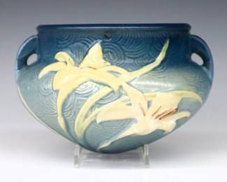 A mid 20th century Roseville Art Pottery hanging planter.  Bulbous form and multi-color Zephyr Lily decoration and Blue matte glaze.  Molded "U.S.A." mark at rim.  Some surface wear and minor discoloration.  7" diameter x 5 1/4" high.  ESTIMATE $50-100