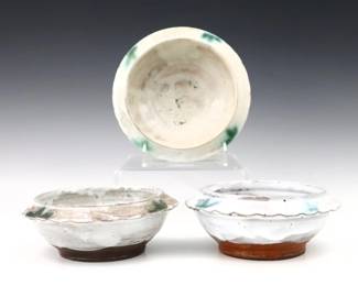 Three 20th century Jugtown Pottery bowls.  Footed forms with piecrust shoulders and mottled Chinese White glaze with Blue details.  Impressed "Jugtown Ware" marks.  One with flakes to piecrust rim, another with crazing and minor discoloration.  Up to 6 1/2" diameter x 2 1/2" high.  ESTIMATE $50-100