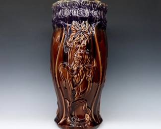 A turn of the century Roseville Art Pottery umbrella stand.  Baluster form with molded floral decoration and multi-color blended glaze.  Unmarked.  Crazing, minor damage.  9 1/4" diameter x 20" high.  ESTIMATE $100-200