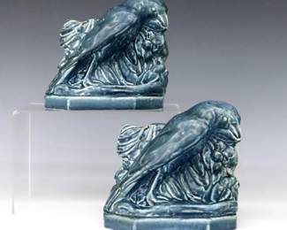 A pair of early 20th century Rookwood Art Pottery bookends designed by William Purcell McDonald (American, 1863-1931).  Molded forms depicting Rooks against a foliate background with Blue matte glaze.  Impressed Rookwood mark with "XXIV" (1924) date and "2275" model number.  Minor wear.  Both 5 1/2 x 5" high.  ESTIMATE $100-200