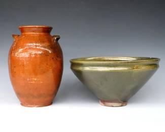 Two pieces of 20th century Jugtown Pottery.  Includes an early Chinese style urn vase with applied handles and mottled Orange glaze, and a footed bowl with Green Frogskin glaze.  Impressed "Jugtown Ware" marks.  Vase with crazing, flakes to body and chips to foot, bowl with flakes at inner rim and large chip to foot.  Vase is 9 1/2" high and bowl is 11 3/4" diameter x 6 1/8" high.  ESTIMATE $50-100