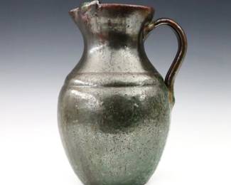 A mid 20th century A.R. Cole Pottery iced tea pitcher.  Baluster form with ice guard, strap handle and mottled Brown/Green glaze.  Impressed "A.R. Cole Pottery / Sanford, N.C." mark.  Minor wear.  10 1/4" high.  ESTIMATE $50-100