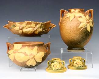 Five pieces of mid 20th century Roseville Art Pottery.  Includes a bulbous vase, hanging basket and low bowl with multi-color Clematis decoration and Orange/Green matte glaze, and a pair of low candlesticks with multi-color Peony decoration and Yellow/Green matte glaze.  Four with molded "Roseville / U.S.A." marks and model numbers, hanging planter with "U.S.A." at rim.  Most pieces with some damage including chips, flakes or hairlines.  Up to 11" long and 8 1/2" high.  ESTIMATE $50-100