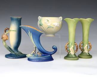 Five pieces of mid 20th century Roseville Art Pottery.  Includes a baluster and cornucopia vase with multi-color Pine Cone decoration and Blue/Green matte glaze, a pair of slender vases with multi-color Apple Blossom decoration and Green matte glaze, and a small planter with multi-color Poppy decoration and Light Yellow/Blue matte glaze.  Molded "Roseville / U.S.A." marks and model numbers, cornucopia vase also with original foil label.  Minor wear, some crazing.  Up to 5" diameter and 7 1/2" high.  ESTIMATE $50-100