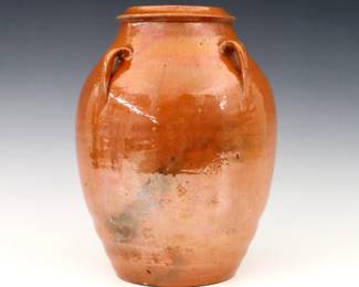 An early 20th century Jugtown Pottery vase.  Chinese style urn form with applied handles and mottled Orange glaze.  Impressed "Jugtown Ware" mark.  Crazing, minor surface wear, a few larger burst air bubbles from production.  9 1/2" high.  ESTIMATE $100-200
