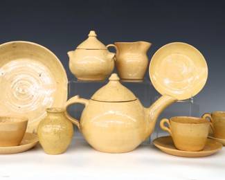 Twelve pieces of 20th century Jugtown Pottery.  Various forms with mottled Light Yellow Buff glaze, includes a pie dish, teapot, creamer and covered sugar, three teacups, four saucers and a small vase.  Impressed "Jugtown Ware" marks.  Crazing and surface wear, most with painted undersides, a couple flakes.  Up to 10 1/4" diameter and 5 3/4" high.  ESTIMATE $50-100